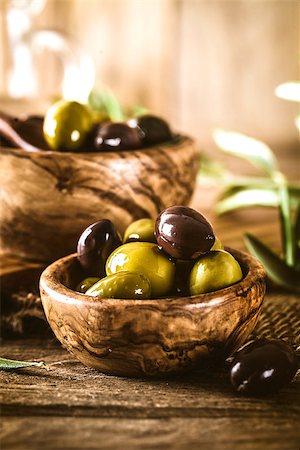 simsearch:400-05666507,k - olives on olive branch. Wooden table with olives in bowl Stock Photo - Budget Royalty-Free & Subscription, Code: 400-08257680