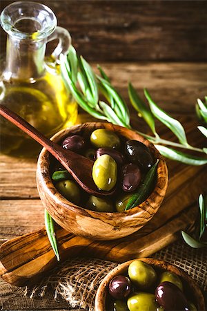 simsearch:400-05666507,k - olives on olive branch. Wooden table with olives in bowl Stock Photo - Budget Royalty-Free & Subscription, Code: 400-08257681