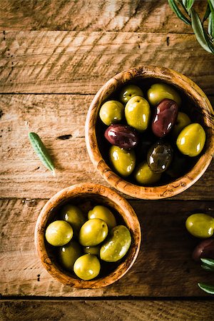 simsearch:400-05666507,k - olives on olive branch. Wooden table with olives in bowl Stock Photo - Budget Royalty-Free & Subscription, Code: 400-08257682