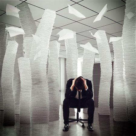 Desperate businessman sitting among piles of papers Stock Photo - Budget Royalty-Free & Subscription, Code: 400-08259740