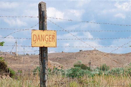 simsearch:400-05300192,k - pillar with a prohibition sign and barbed wire fence Stock Photo - Budget Royalty-Free & Subscription, Code: 400-08250450