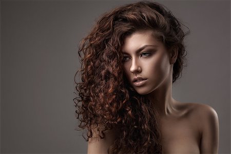 simsearch:400-09081321,k - studio shot of woman with healthy brown curly hair isolated over grey background Stock Photo - Budget Royalty-Free & Subscription, Code: 400-08250538