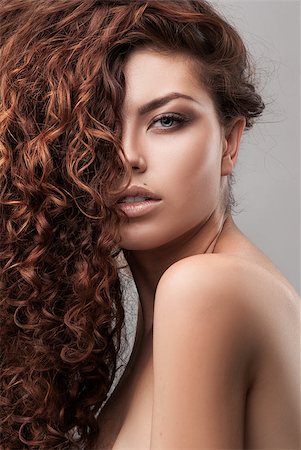 simsearch:400-09081321,k - studio shot of woman with healthy brown curly hair isolated over grey background Stock Photo - Budget Royalty-Free & Subscription, Code: 400-08250984