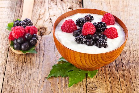 yogurt with wild berries in wooden bowl on wooden background Stock Photo - Budget Royalty-Free & Subscription, Code: 400-08251074