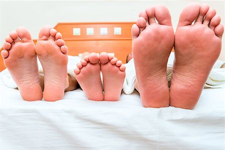 sleeping man foot - family of three people sleeping in one bed, feet close-up Photographie de stock - Aubaine LD & Abonnement, Code: 400-08251107