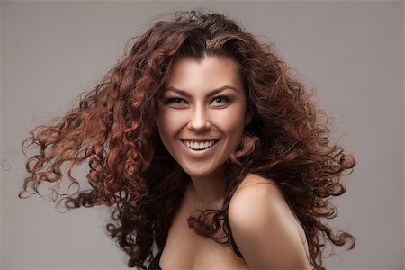 simsearch:400-09081321,k - studio shot of smiling woman with healthy brown curly hair isolated over grey background Stock Photo - Budget Royalty-Free & Subscription, Code: 400-08251305