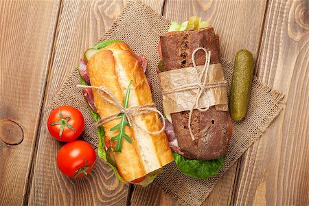 simsearch:400-07099478,k - Two sandwiches with salad, ham, cheese and tomatoes on wooden table. Top view Stock Photo - Budget Royalty-Free & Subscription, Code: 400-08251546