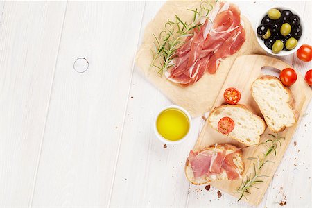 Bruschetta with tomatoes and prosciutto on cutting board. Top view with copy space Stock Photo - Budget Royalty-Free & Subscription, Code: 400-08251583
