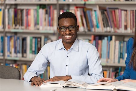 Portrait Of Clever Black Student With Open Book Reading It In College Library - Shallow Depth Of Field Stock Photo - Budget Royalty-Free & Subscription, Code: 400-08251801