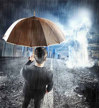 Man with umbrella sheltering from the storm Stock Photo - Budget Royalty-Free & Subscription, Code: 400-08252456