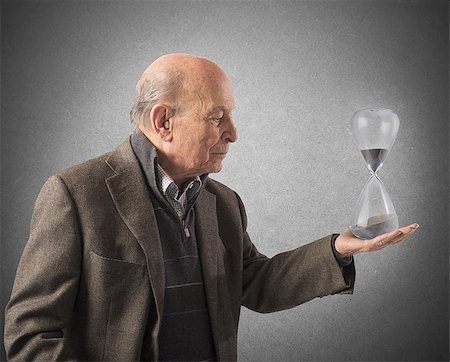 simsearch:400-05746567,k - Elderly man holds an hourglass in hand Stock Photo - Budget Royalty-Free & Subscription, Code: 400-08252711