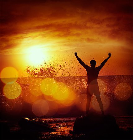 simsearch:400-04662543,k - Silhouette of Man with Raised Arms against Stormy Sea over Dramatic Sunset. Motivation and Strength Concept. Filtered Photo with Bokeh. Stock Photo - Budget Royalty-Free & Subscription, Code: 400-08253129