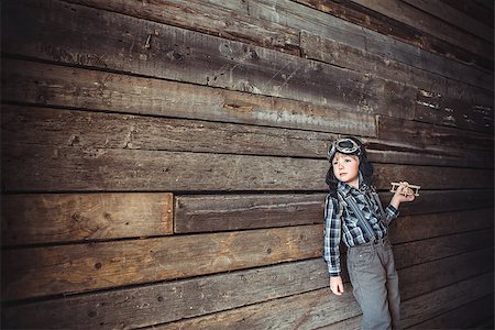 Boy with airplane on the background of wooden wall Stock Photo - Budget Royalty-Free & Subscription, Code: 400-08253685