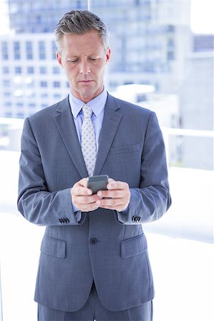 simsearch:400-07927298,k - Businessman texting with his smartphone in the office Foto de stock - Royalty-Free Super Valor e Assinatura, Número: 400-08264487