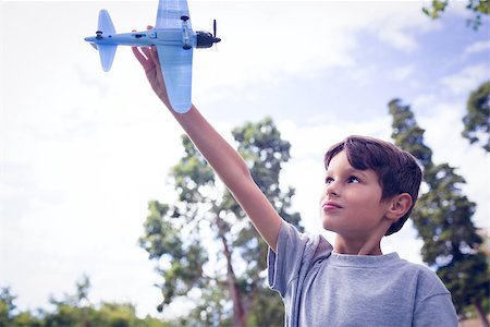 simsearch:400-07474903,k - Boy playing with a toy plane at park on a sunny day Foto de stock - Super Valor sin royalties y Suscripción, Código: 400-08264737