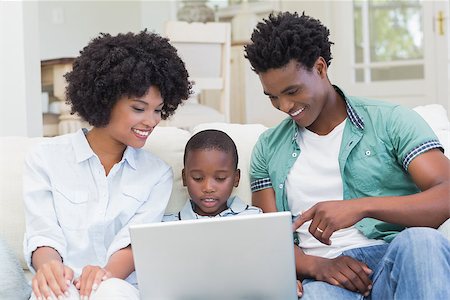 Happy family on the couch with laptop at home in the living room Stock Photo - Budget Royalty-Free & Subscription, Code: 400-08265535