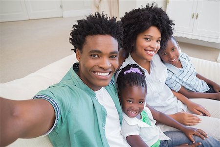 Happy family taking a selfie on the couch at home in the living room Stock Photo - Budget Royalty-Free & Subscription, Code: 400-08265564