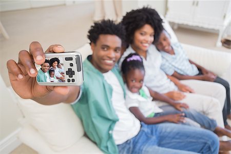 Happy family taking a selfie on the couch at home in the living room Stock Photo - Budget Royalty-Free & Subscription, Code: 400-08265563