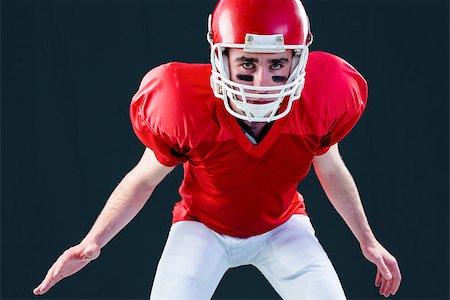 simsearch:6109-08389992,k - A serious american football player taking his helmet looking at camera with black background Stock Photo - Budget Royalty-Free & Subscription, Code: 400-08265661