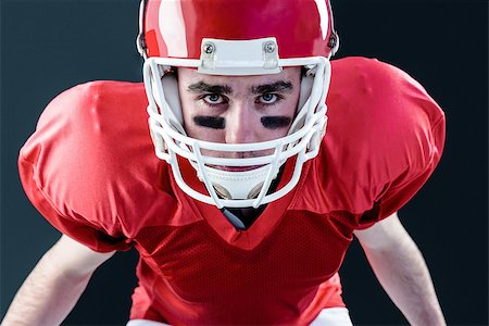 simsearch:625-02931241,k - A serious american football player taking his helmet looking at camera with black background Fotografie stock - Microstock e Abbonamento, Codice: 400-08265662
