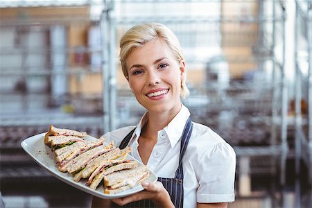 retail sandwich - Selfassured female cook smiling holding sandwiches Stock Photo - Budget Royalty-Free & Subscription, Code: 400-08265851