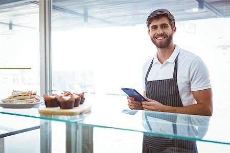 restaurant owner tablet - Handsome worker posing on the counter with a tablet at the bakery Stock Photo - Budget Royalty-Free & Subscription, Code: 400-08265884