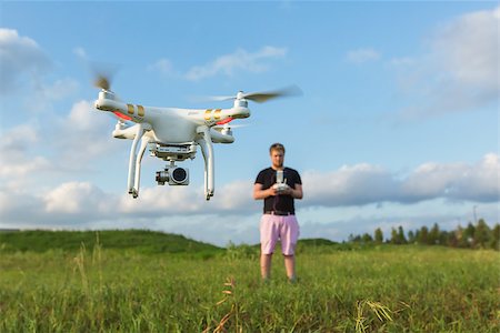 simsearch:877-08129456,k - Person in field controlling drone with camera Photographie de stock - Aubaine LD & Abonnement, Code: 400-08261576