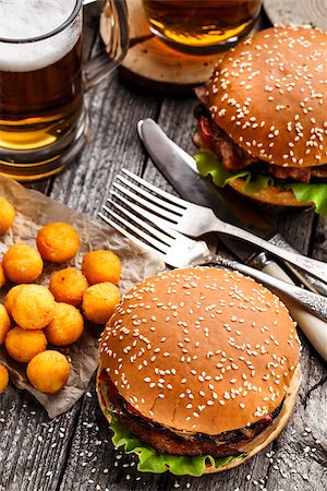 Delicious burgers with fried potato balls and beer on a rustic table Stock Photo - Budget Royalty-Free & Subscription, Code: 400-08284222