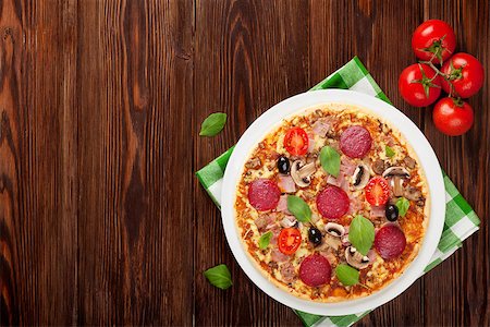 simsearch:400-08960199,k - Italian pizza with pepperoni, tomatoes, olives and basil on wooden table. Top view with copy space Stock Photo - Budget Royalty-Free & Subscription, Code: 400-08284685