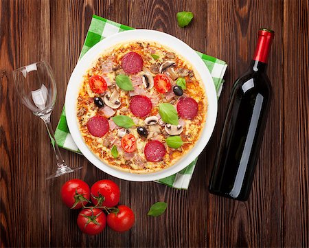 simsearch:400-08960199,k - Italian pizza with pepperoni, tomatoes, olives, basil and red wine on wooden table. Top view Stock Photo - Budget Royalty-Free & Subscription, Code: 400-08284686
