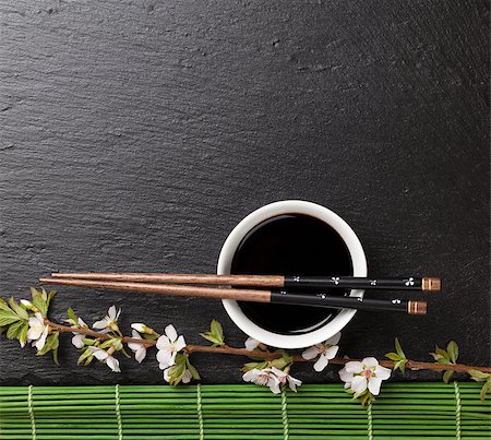 sushi plate - Japanese sushi chopsticks, soy sauce bowl and sakura blossom on black stone background. Top view with copy space Stock Photo - Budget Royalty-Free & Subscription, Code: 400-08284713