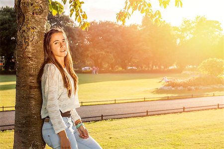 Closeup of beautiful casual teen leaning on a tree Stock Photo - Budget Royalty-Free & Subscription, Code: 400-08285059