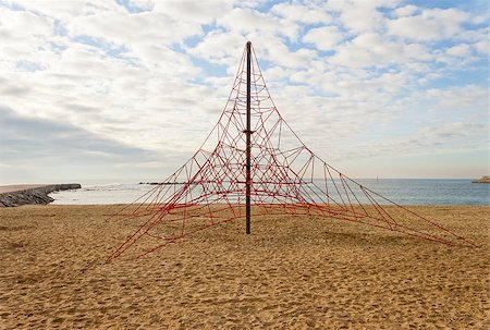 photojope (artist) - Empty red rope pyramid playground for climbing. Nobody in the beach and the sky is cloudy. Fotografie stock - Microstock e Abbonamento, Codice: 400-08285195