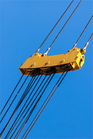 Large yellow pulley assembly with three sets of pulleys and tightly stretched diagonal steel cables above and below. Fotografie stock - Microstock e Abbonamento, Codice: 400-08285593