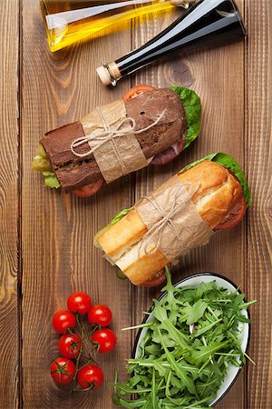 simsearch:400-07099478,k - Two sandwiches with salad, ham, cheese and tomatoes, salad and spices on wooden table. Top view Stock Photo - Budget Royalty-Free & Subscription, Code: 400-08286442