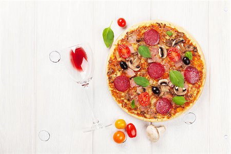 simsearch:400-07481818,k - Italian pizza with pepperoni, tomatoes, olives, basil and red wine on wooden table. Top view with copy space Foto de stock - Super Valor sin royalties y Suscripción, Código: 400-08286460