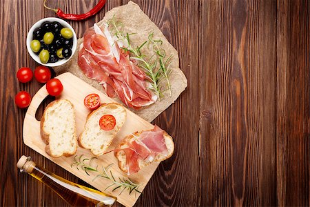 simsearch:400-08291219,k - Bruschetta ingredients - prosciutto, olives, tomatoes. Top view on wooden table Stock Photo - Budget Royalty-Free & Subscription, Code: 400-08287265