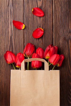 simsearch:400-08036453,k - Red tulips bouquet in paper bag over wooden table background with copy space Stock Photo - Budget Royalty-Free & Subscription, Code: 400-08287275