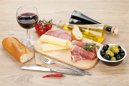 simsearch:400-07481817,k - Red wine with cheese, olives, tomatoes, prosciutto, bread and spices. Over wooden table background. View from above with copy space Stock Photo - Budget Royalty-Free & Subscription, Code: 400-08287436