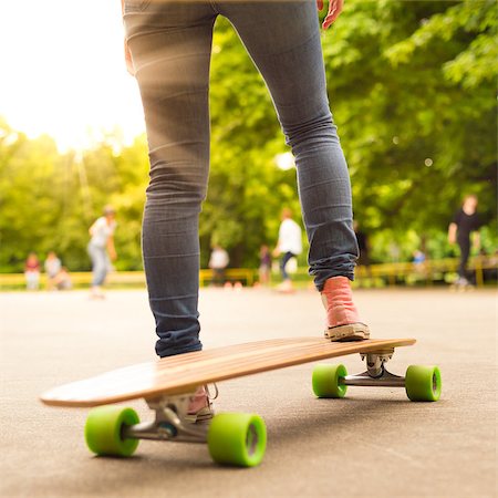 simsearch:400-07507525,k - Teenage girl wearing blue jeans and sneakers practicing long board riding in skateboarding park. Active urban life. Urban subculture. Stock Photo - Budget Royalty-Free & Subscription, Code: 400-08287950