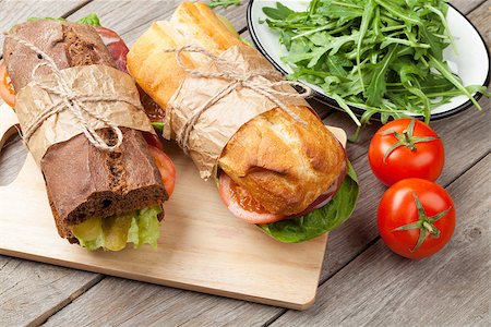 simsearch:400-07099478,k - Two sandwiches with salad, ham, cheese and tomatoes on cutting board Stock Photo - Budget Royalty-Free & Subscription, Code: 400-08288454