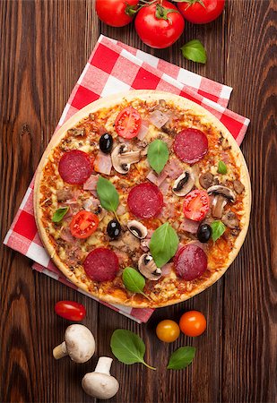 simsearch:400-08291219,k - Italian pizza with pepperoni, tomatoes, olives and basil on wooden table. Top view Stock Photo - Budget Royalty-Free & Subscription, Code: 400-08288460