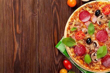 simsearch:400-07893141,k - Italian pizza with pepperoni, tomatoes, olives and basil on wooden table. Top view with copy space Photographie de stock - Aubaine LD & Abonnement, Code: 400-08288461