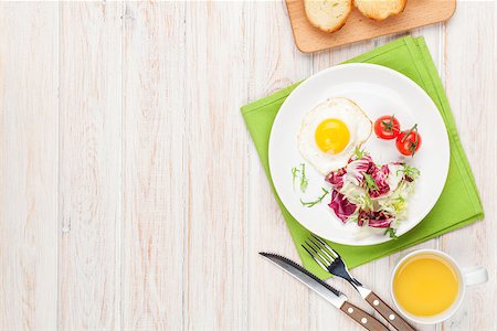 simsearch:400-06094801,k - Healthy breakfast with fried egg, toasts and salad on white wooden table. Top view with copy space Photographie de stock - Aubaine LD & Abonnement, Code: 400-08288676