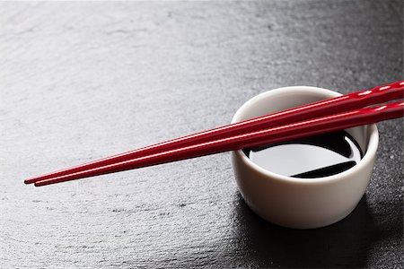 salsa de soja - Japanese sushi chopsticks over soy sauce bowl on black stone background. Top view with copy space Photographie de stock - Aubaine LD & Abonnement, Code: 400-08289459