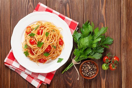 pasta dish with olives on white background - Spaghetti pasta with tomatoes and parsley on wooden table. Top view Stock Photo - Budget Royalty-Free & Subscription, Code: 400-08289577