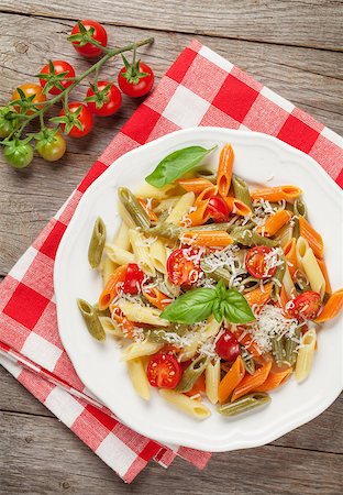 Colorful penne pasta with tomatoes and basil on wooden table. Top view Stock Photo - Budget Royalty-Free & Subscription, Code: 400-08289573