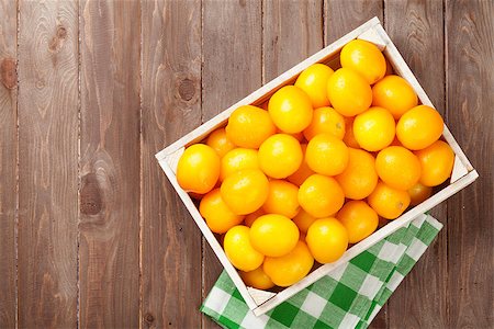 simsearch:400-07212038,k - Yellow tomatoes box on wooden table. Top view Stock Photo - Budget Royalty-Free & Subscription, Code: 400-08289591