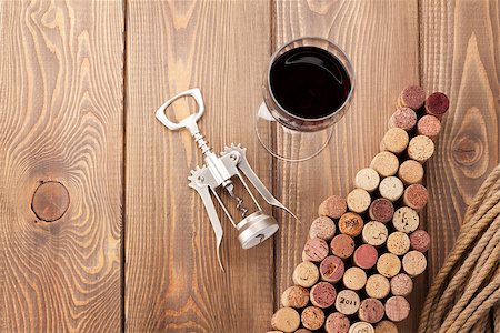 simsearch:400-07933837,k - Wine bottle shaped corks, glass of wine and corkscrew over rustic wooden table background. View from above with copy space Stockbilder - Microstock & Abonnement, Bildnummer: 400-08289646