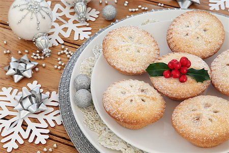 Christmas mince pies, bauble decorations, snowflakes and holly over oak background. Stock Photo - Budget Royalty-Free & Subscription, Code: 400-08282465